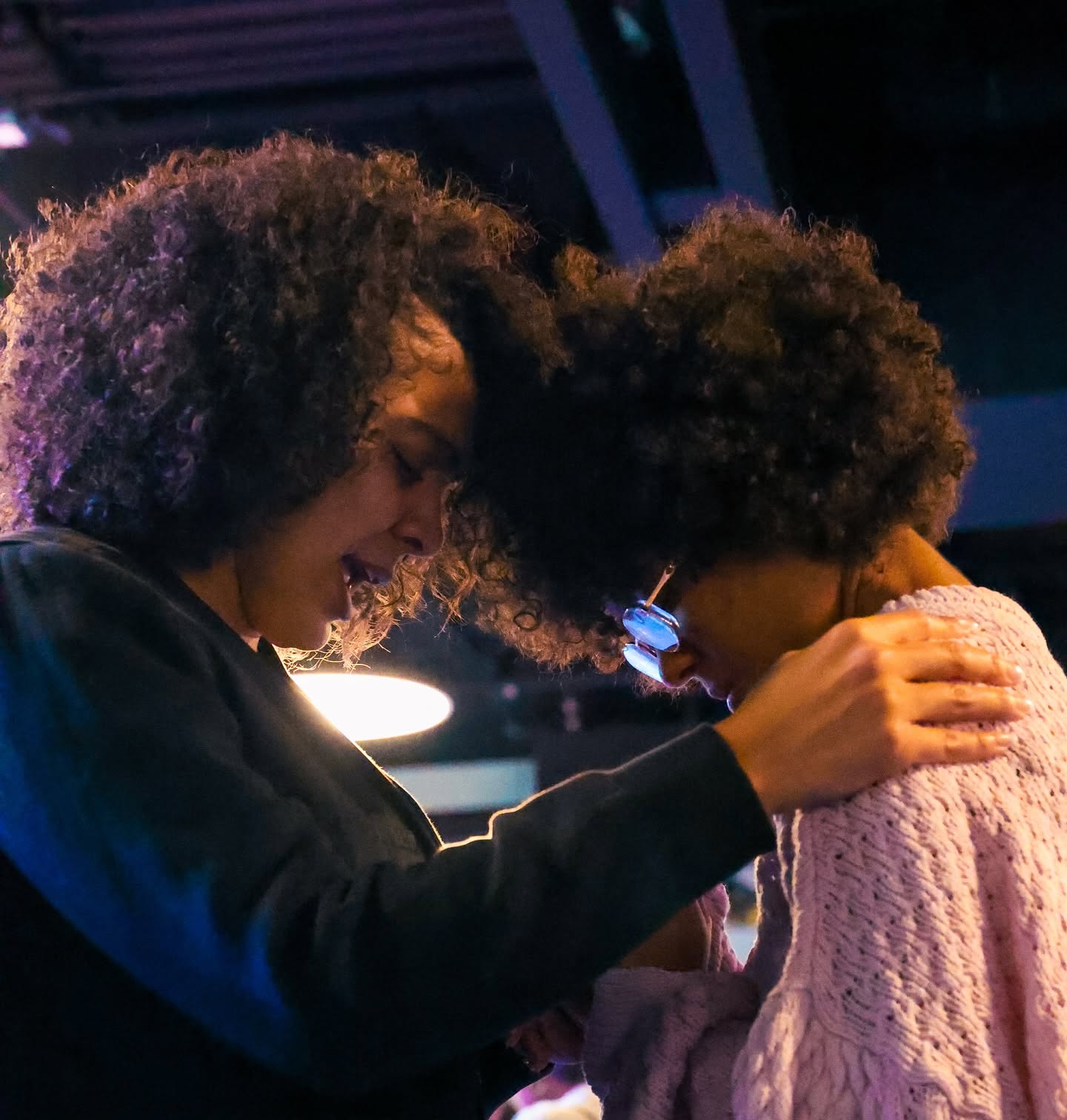Two women praying together during a service